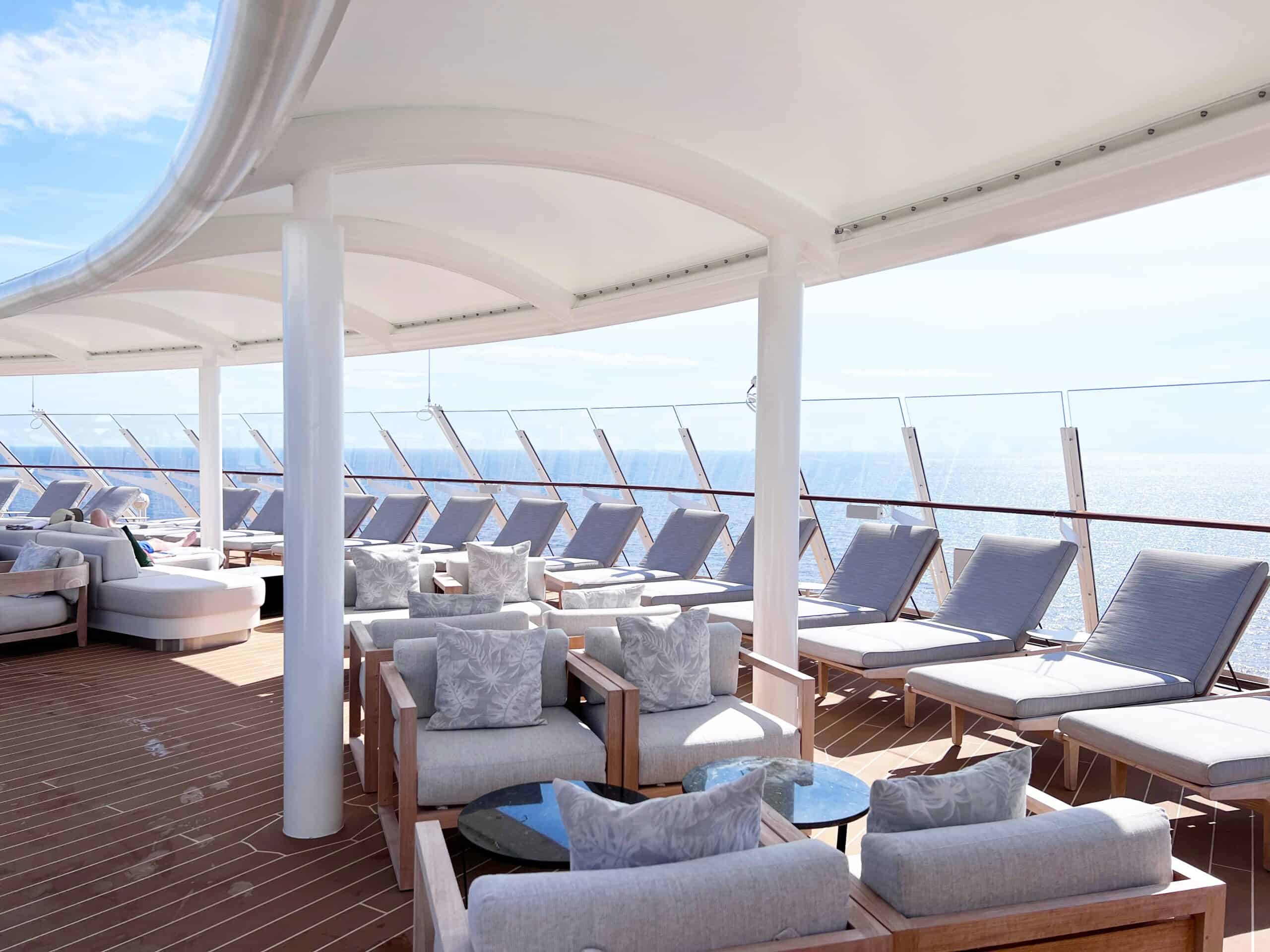 A private concierge sun deck on a Disney cruise ship with loungers and hot tubs