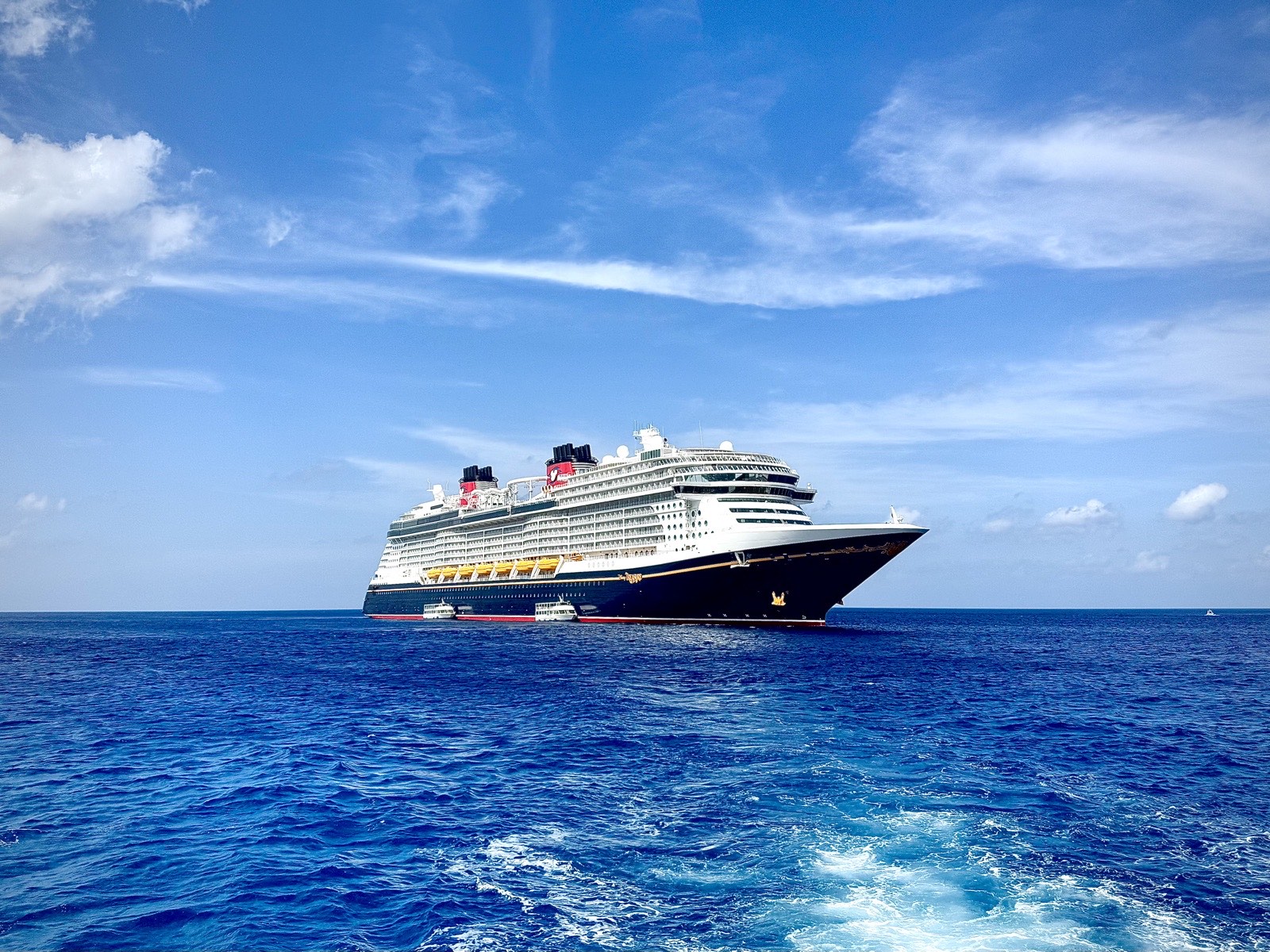 The Disney Treasure cruise ship at anchor in bright blue Caribbean water