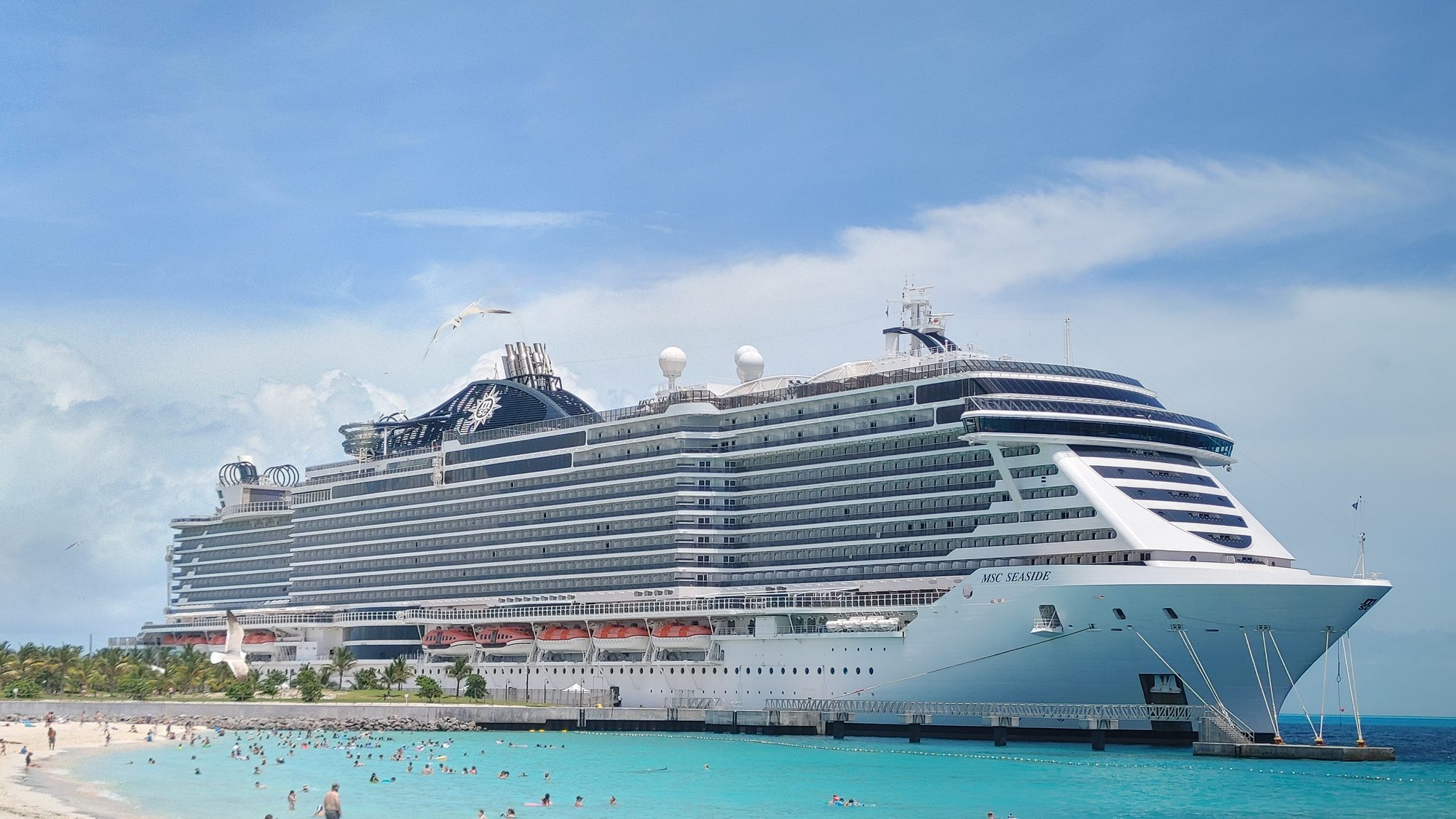 MSC Seaside docked at Ocean Cay MSC Marine Reserve with families swimming at the beach